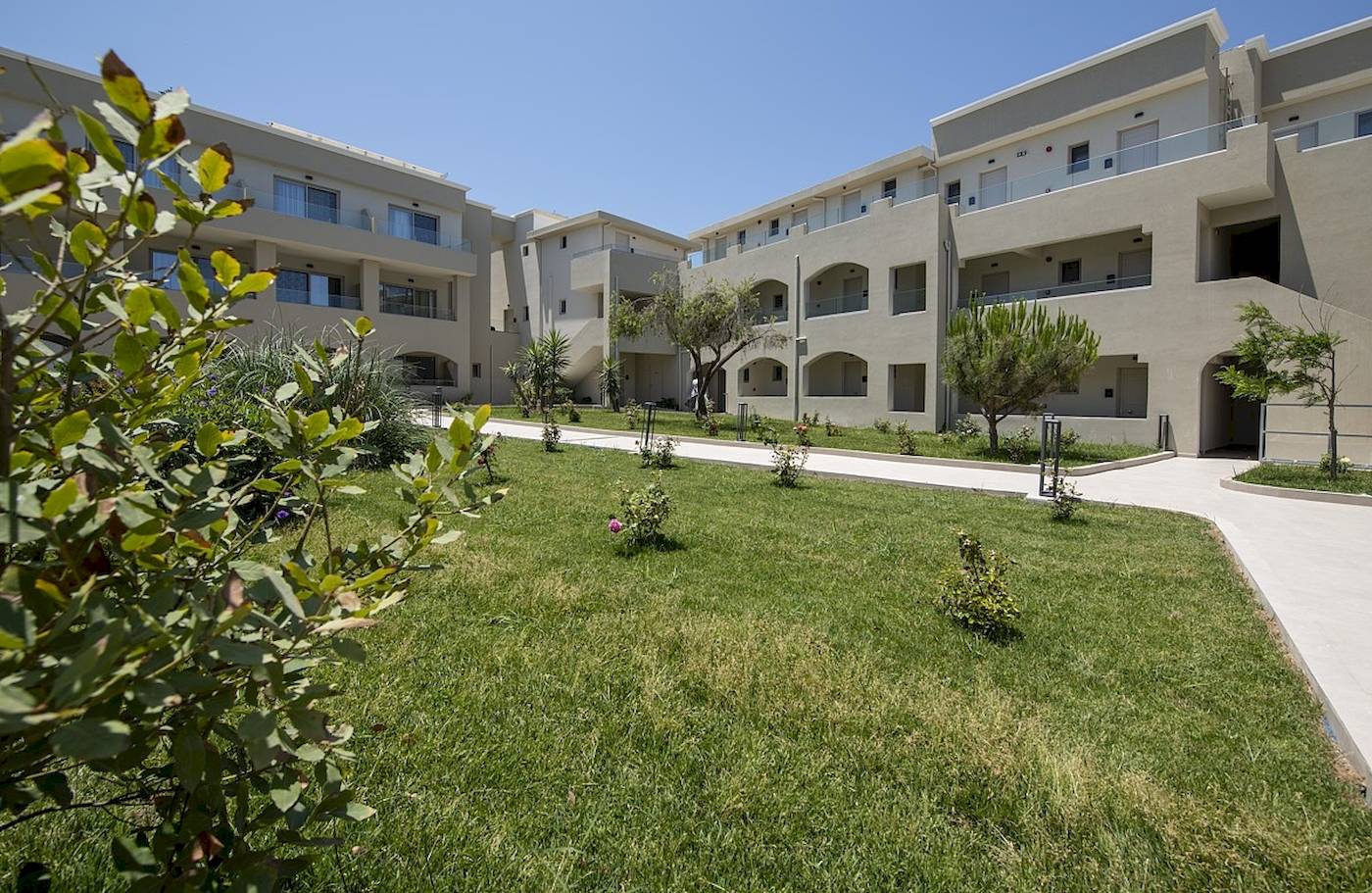 Außenbereich des Vantaris Luxury Beach Resorts mit gepflegtem Rasen und Gebäuden.