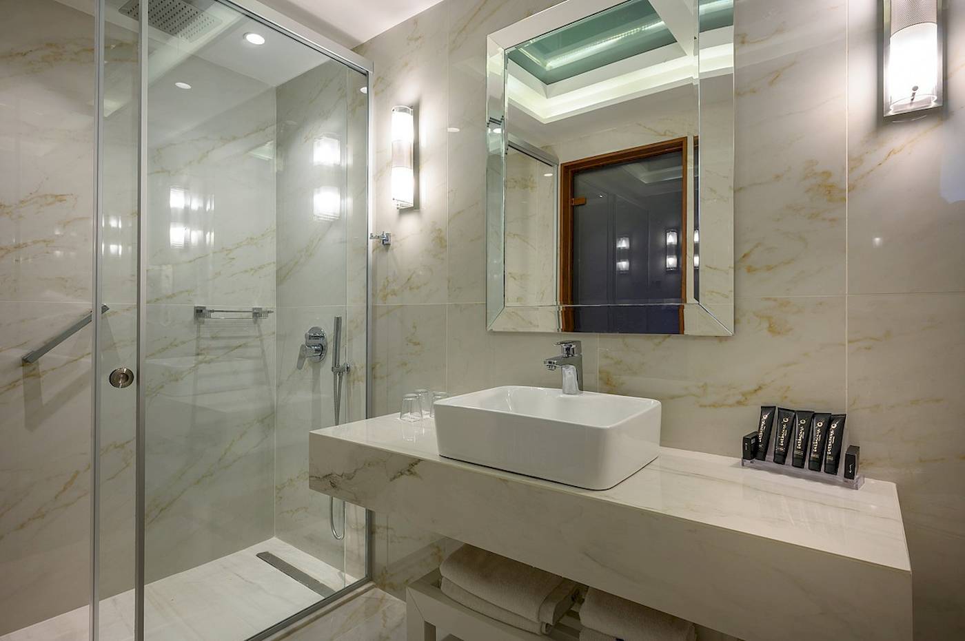 Badezimmer im Vantaris Palace Hotel mit Marmorboden und weißen Fliesen.