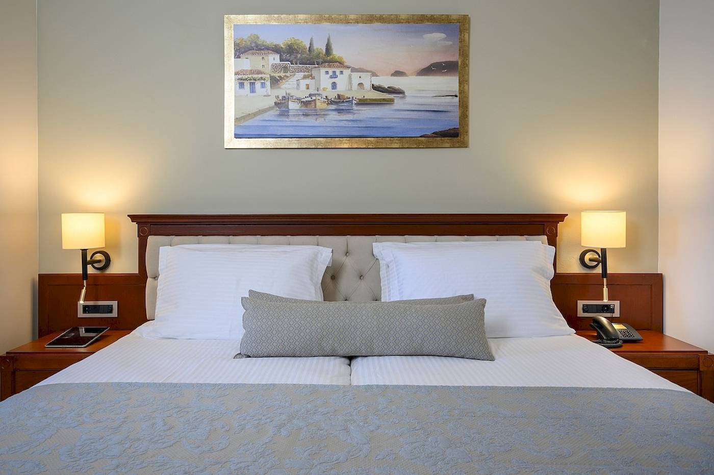 Bett im Vantaris Palace Hotelzimmer mit Dekor und Gemälde an der Wand