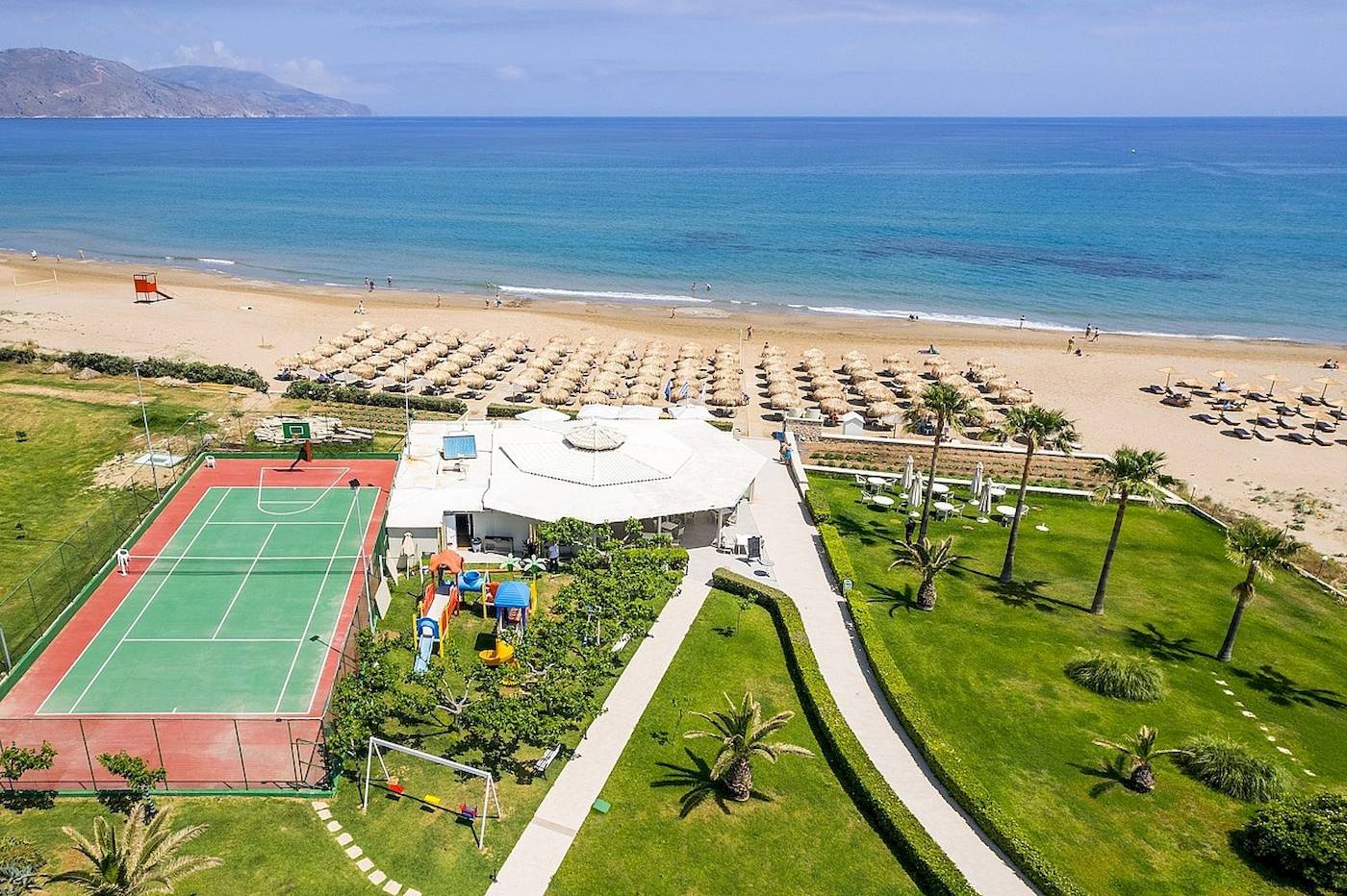 Luftaufnahme des Vantaris Palace Hotels mit Strand, Tennisplatz und Spielplatz