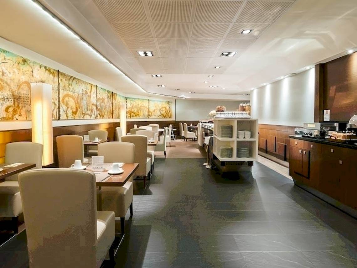 Frühstücksraum im Colonial Barcelona Hotel mit Tisch, Stühlen und Speisen.