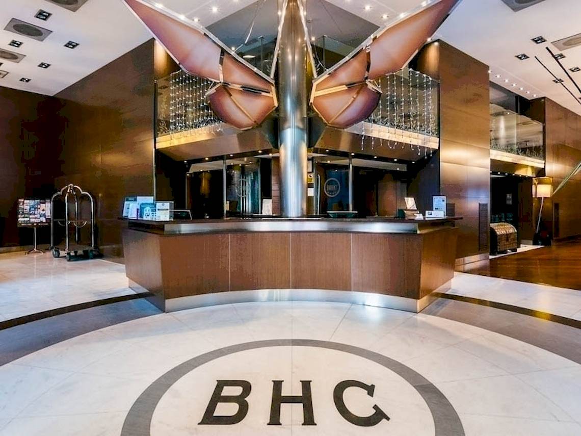 Empfangsbereich des Colonial Barcelona Hotels mit Logo und zentralem Empfangstresen.