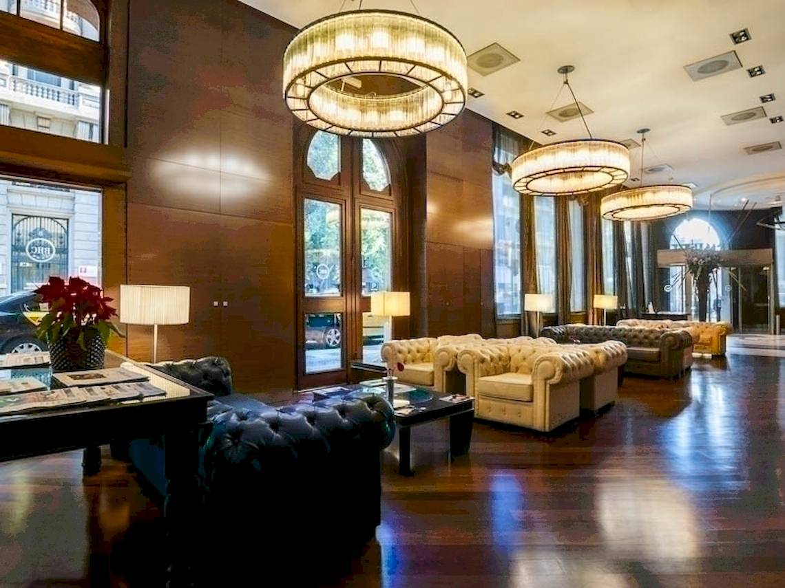 Empfangsbereich des Colonial Barcelona Hotels mit Sofas, Lampen und Holzböden.