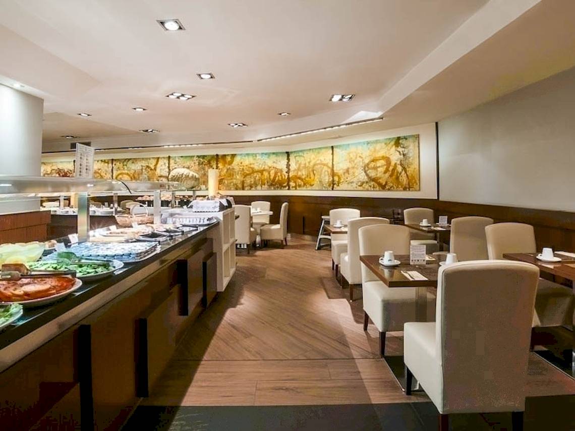 Innenansicht des Restaurants im Colonial Barcelona Hotel mit Buffet und Tischen.