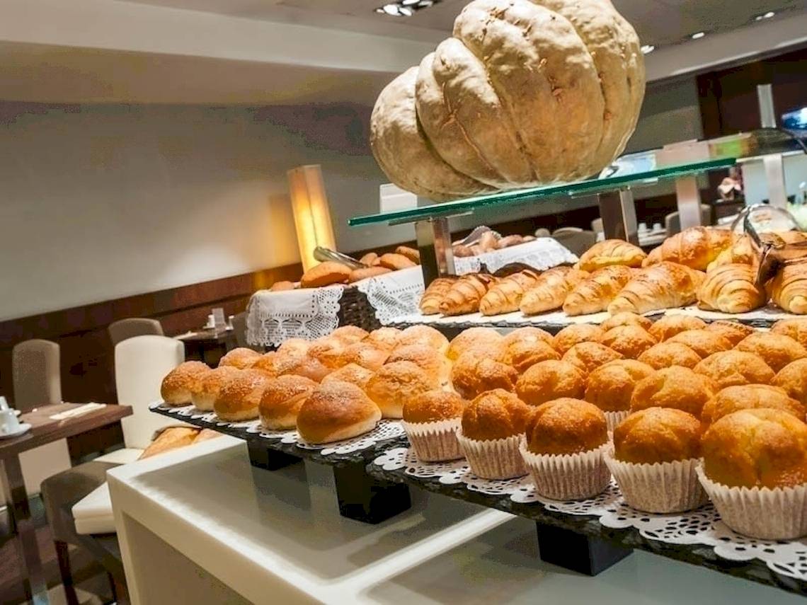 Frühstücksbuffet im Colonial Barcelona Hotel mit verschiedenen Brötchen, Croissants und Muffins.