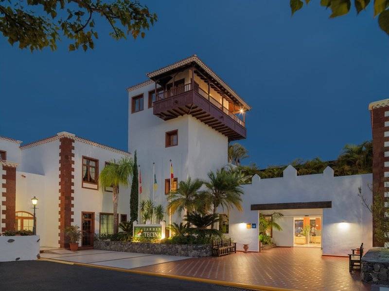 Außenansicht des Jardin Tecina Hotels bei Nacht mit beleuchteter Fassade und Eingangsbereich.
