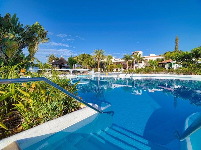 Außenpool des Jardin Tecina Hotels umgeben von tropischer Vegetation und Gebäuden