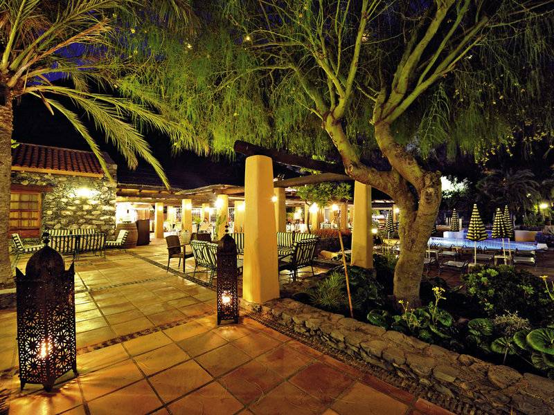 Außenterrasse des Jardin Tecina Hotels bei Nacht mit beleuchteten Möbeln und Bäumen.