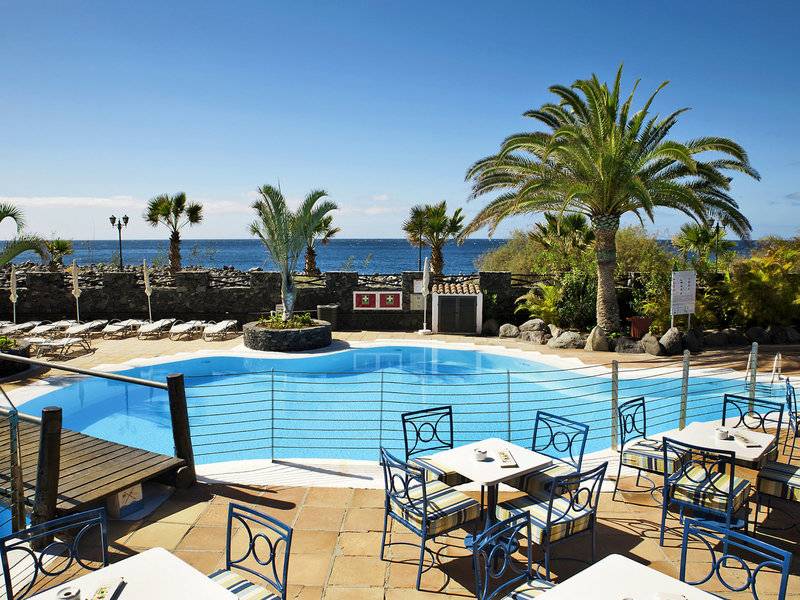 Außenpool des Jardin Tecina Hotels mit Blick auf das Meer und Lounge-Bereich