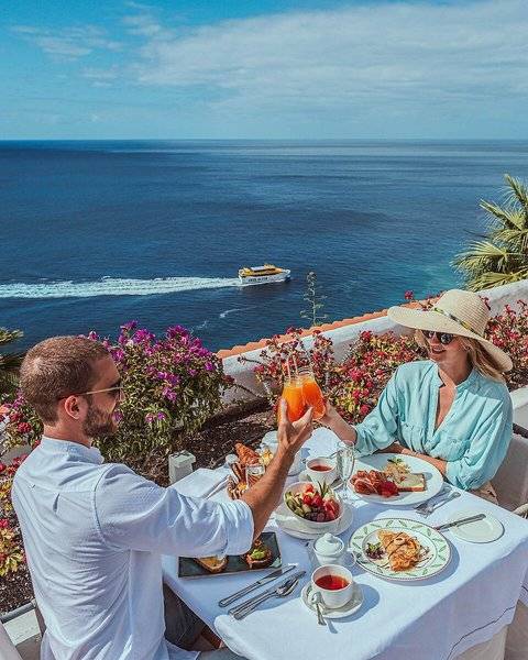 Frühstück am Pool im Jardin Tecina mit Blick auf das Meer und eine vorbeifahrende Fähre.