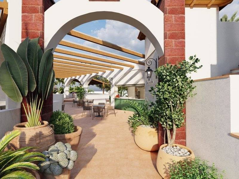 Begrünte Terrasse des Jardin Tecina Hotels mit Tischen und Stühlen unter einer Pergola