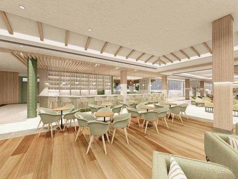 Innenbereich des Jardin Tecina Hotels mit grünen Stühlen, hölzernen Tischen und einer Bar.