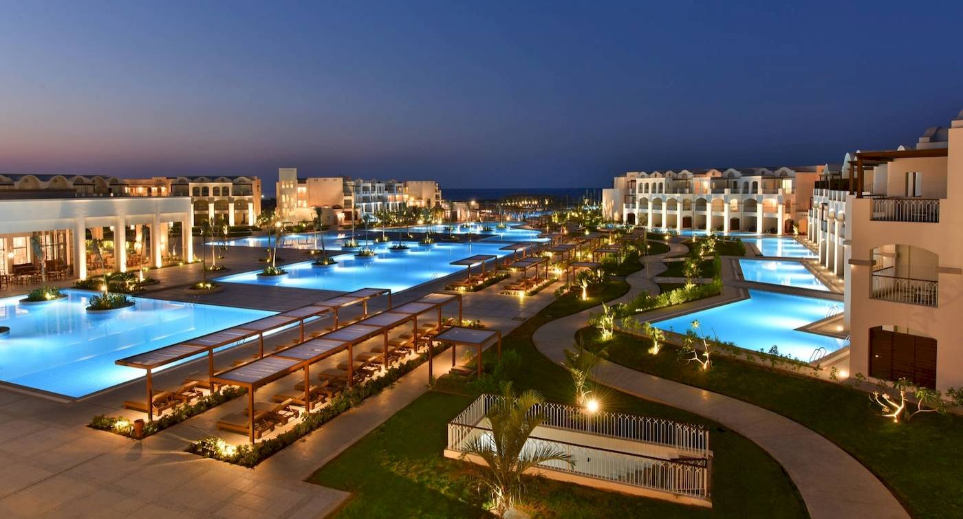 Abendansicht des Steigenberger Resorts Alaya mit Swimmingpools und Gebäuden.