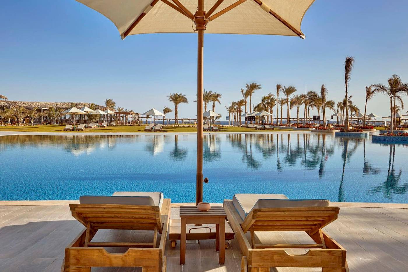 Poolbereich des Steigenberger Resorts Alaya mit zwei Liegen und einem Schirm