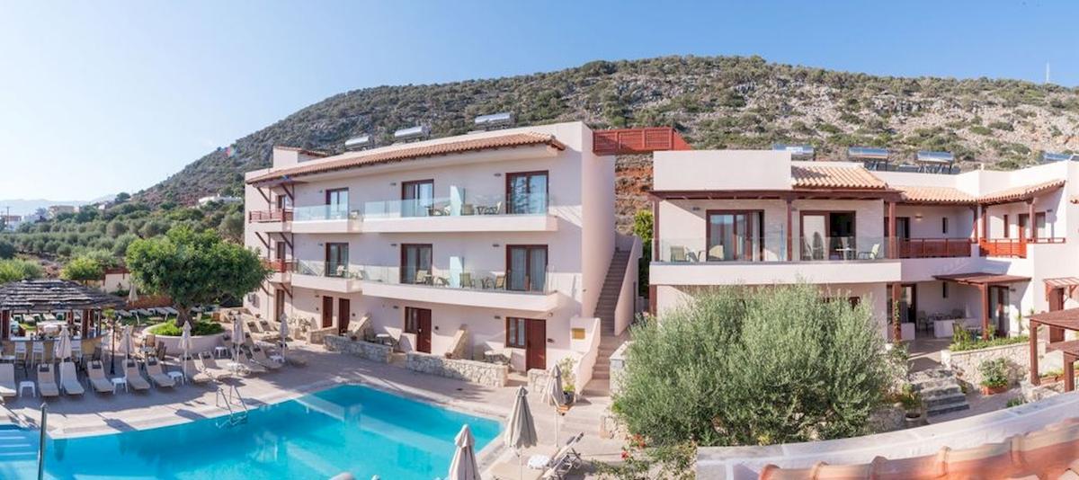 Außenansicht des Cactus Village Hotel & Bungalows mit Swimmingpool und Berg im Hintergrund.