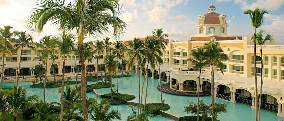 Außenansicht des JOIA Bávaro by Iberostar Hotels mit Swimmingpool und Palmen