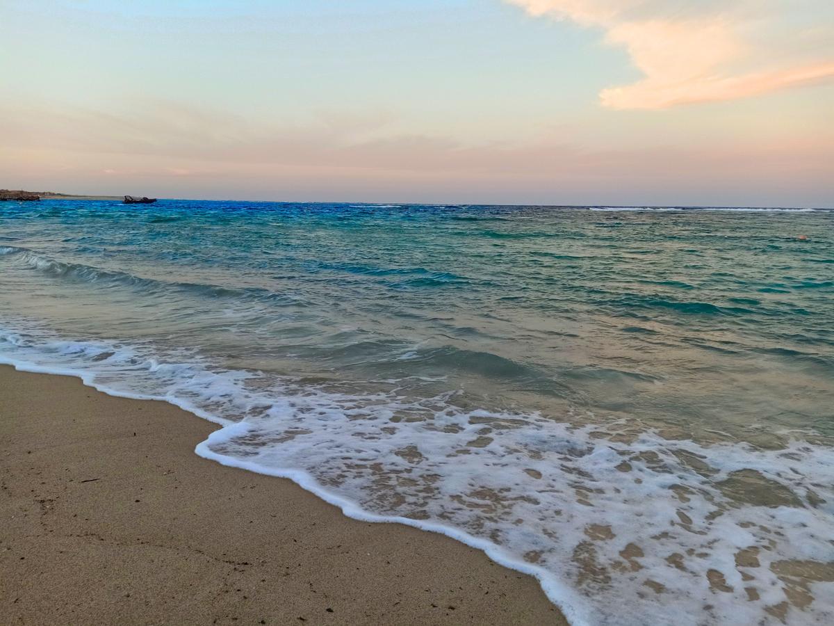 Foto vom Utopia Beach Club zeigt das Meer am Abend mit sanften Wellen am Strand.