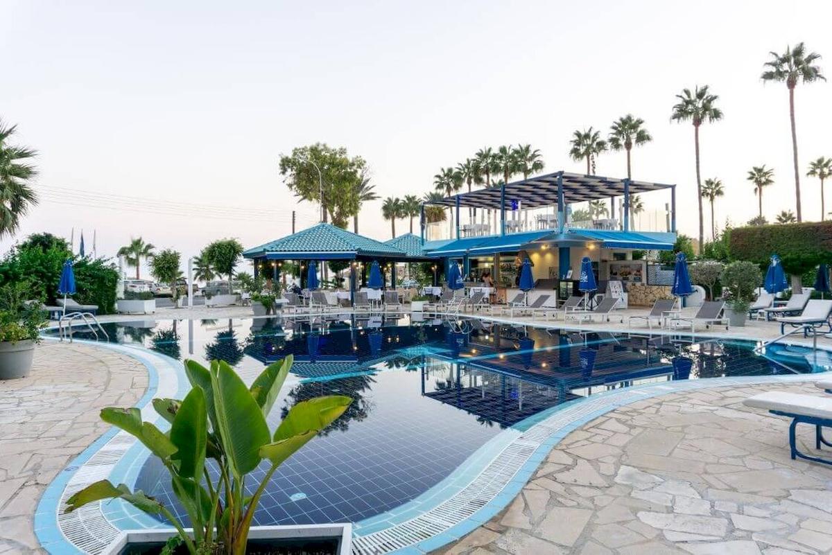 Außenpool des Anonymous Beach Hotels mit Lounge-Stühlen und Sonnenschirmen.
