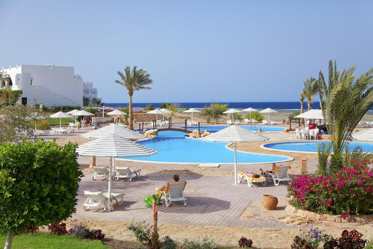 Außenpools mit Sonnenliegen und Sonnenschirmen im Three Corners Equinox Beach Resort