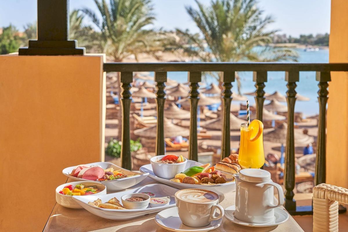 Frühstücksbuffet im Drei-Ecken-Rihana-Resort mit Blick auf das Meer und Palmen.