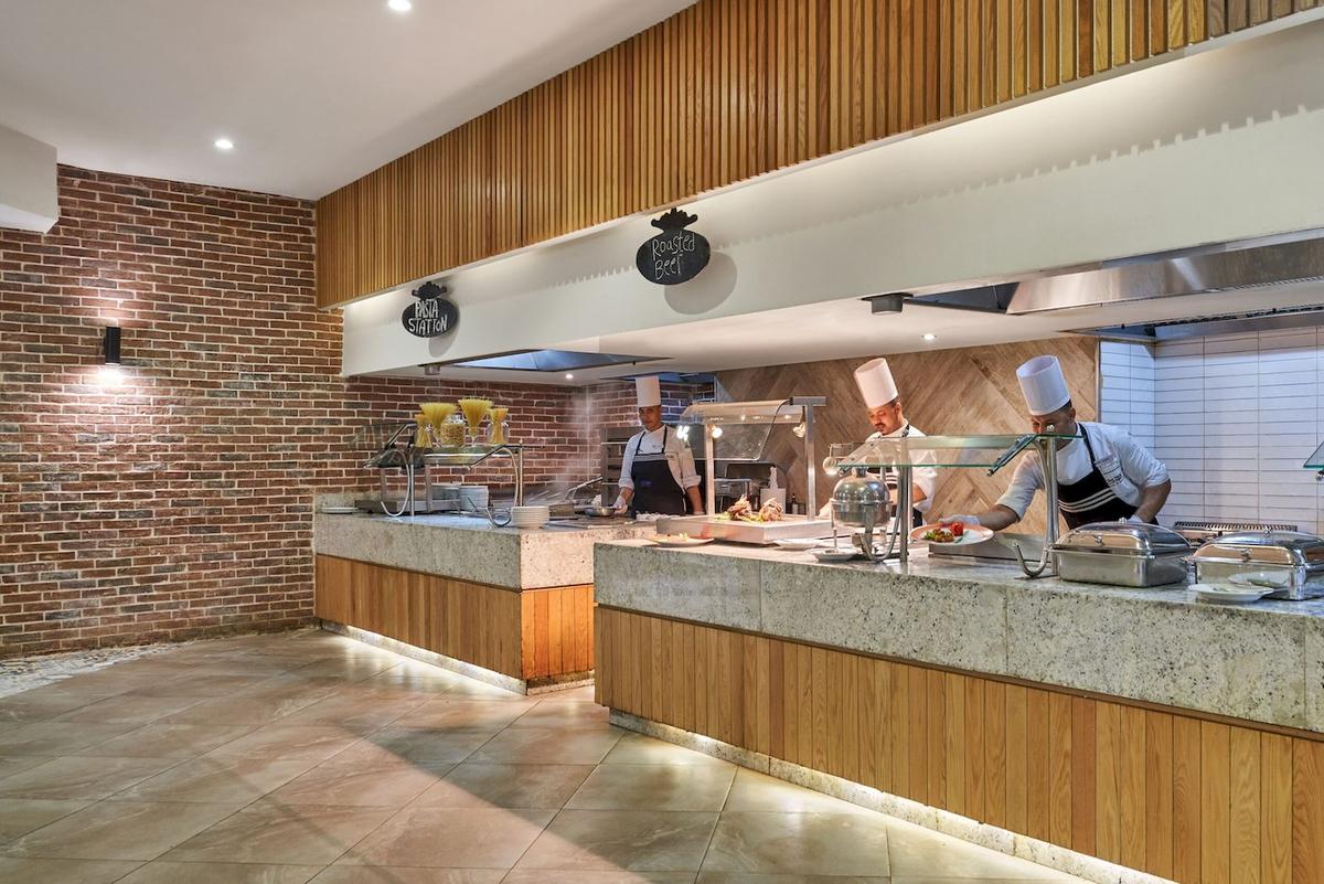 Kueche im Three Corners Rihana Resort mit 3 Kochen an Stationen