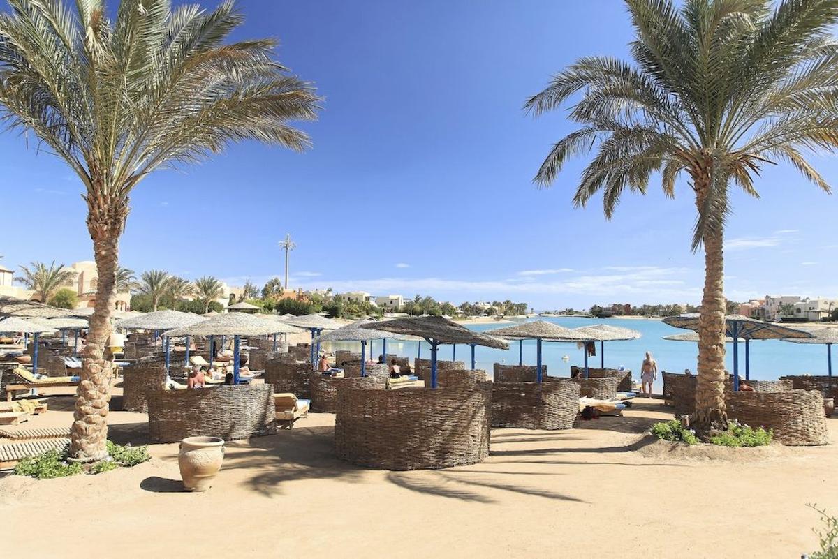 Strand des Three Corners Rihana Resorts mit Sonnenliegen und Palmen