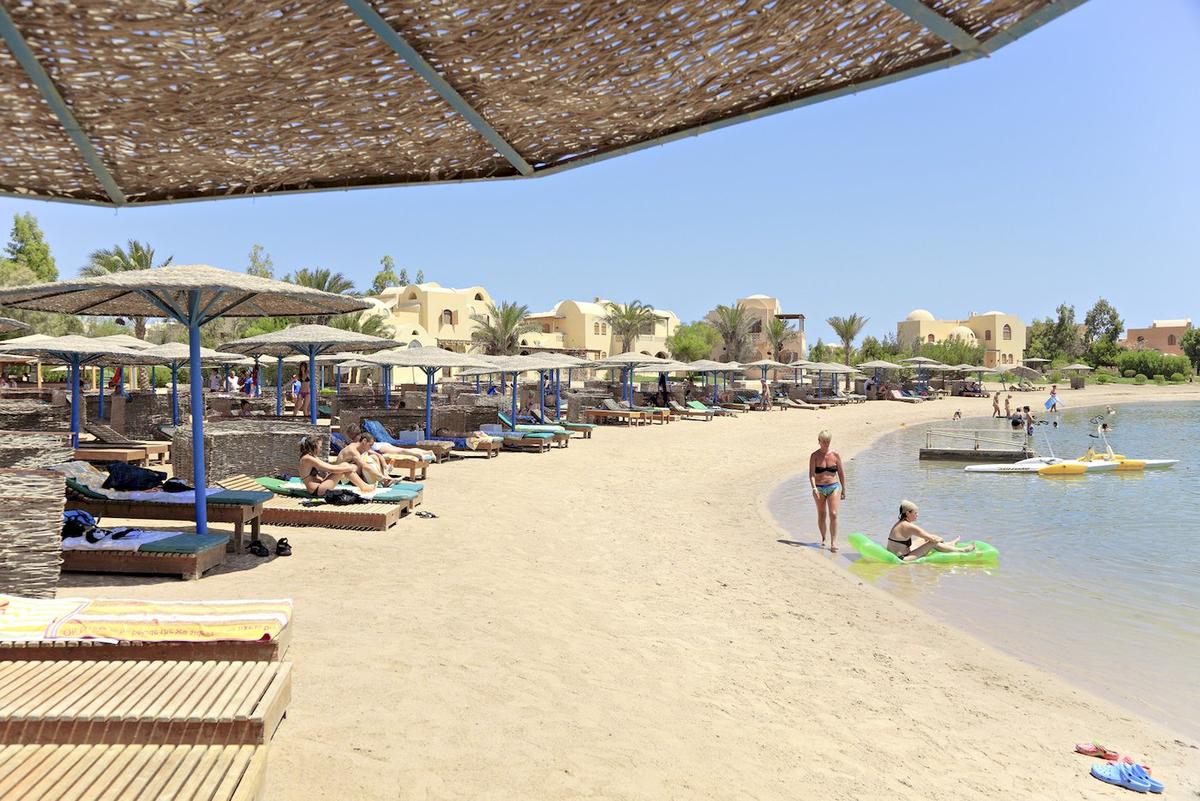 Strand mit Sonnenschirmen und Liegen im Three Corners Rihana Resort.