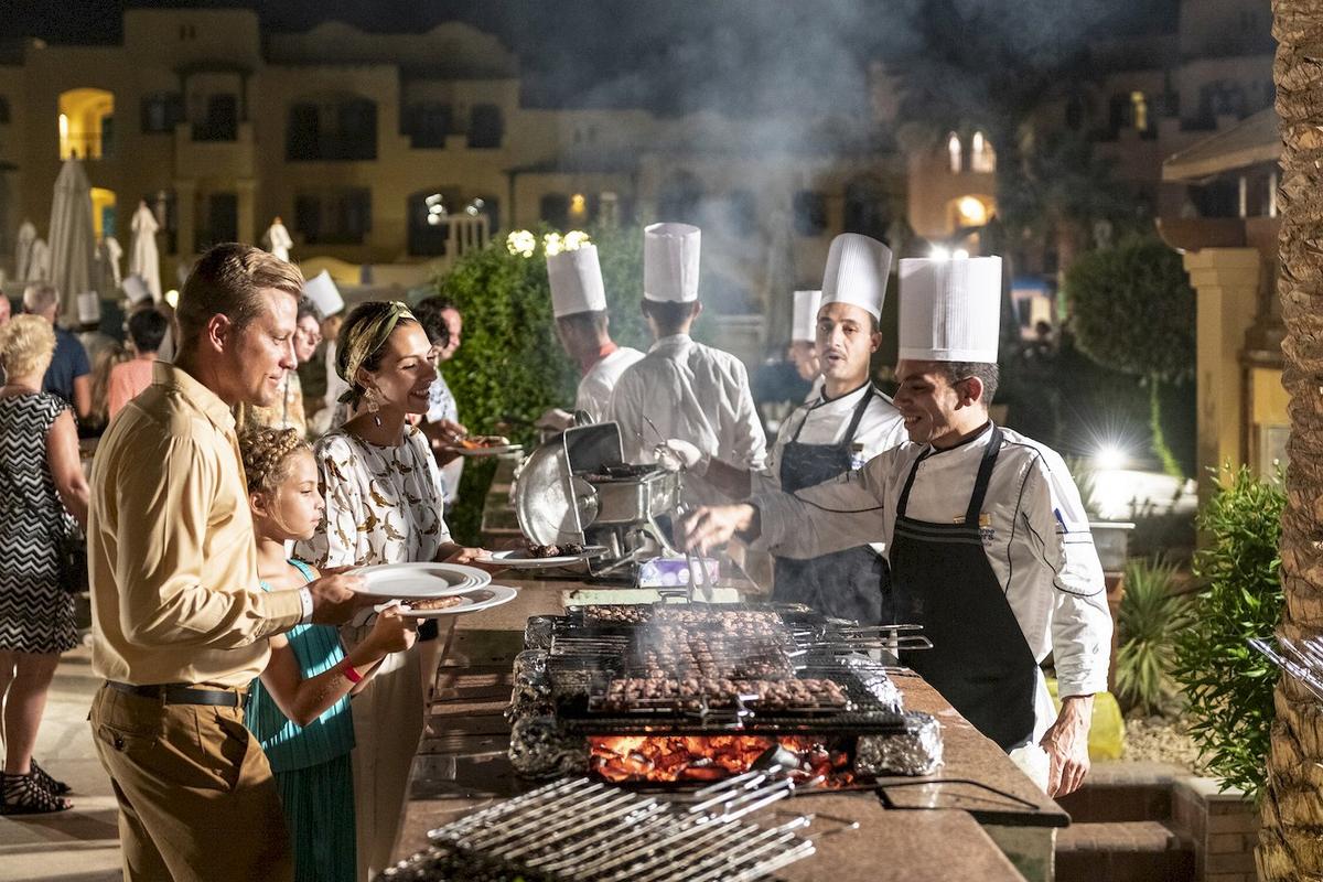 Ein Abendessen im Freien mit Köchen, die am Grill Fleisch zubereiten, im Three Corners Rihana Resort.