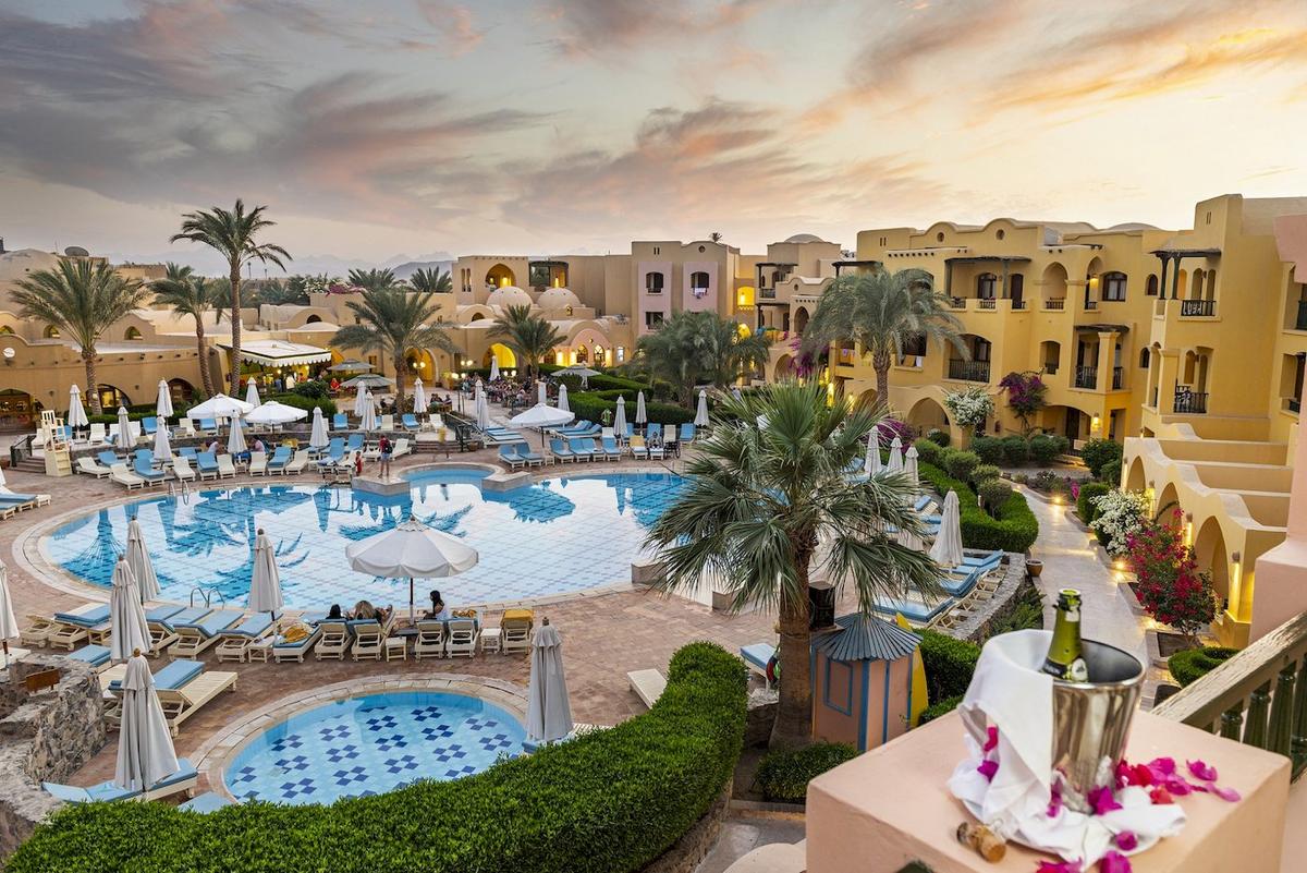 Außenbereich des Three Corners Rihana Resorts mit Swimmingpool und Liegen.