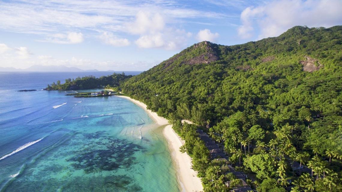 Luftaufnahme des Hilton Seychelles Labriz Resorts & Spa, umgeben von grüner Vegetation und einem weißen Strand.