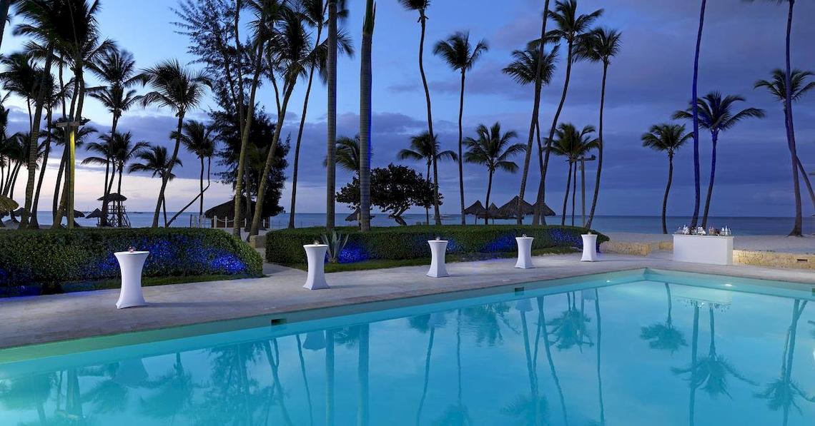 Poolbereich des Melia Caribe Beach Resorts mit Palmen und Meer im Hintergrund