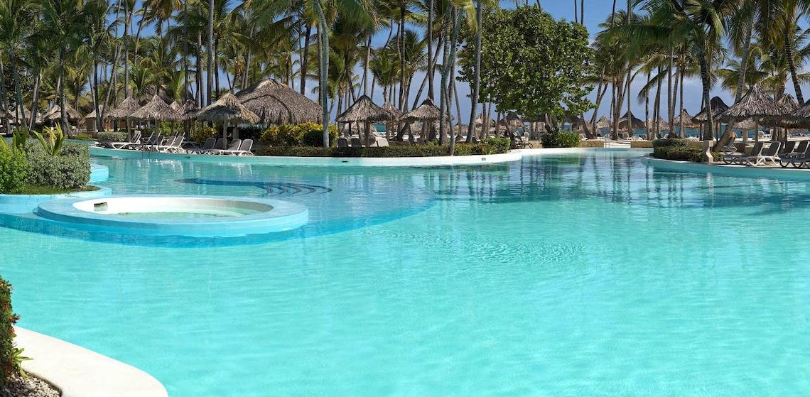 Außenpool des Melia Caribe Beach Resort mit Sonnenliegen und Palmen