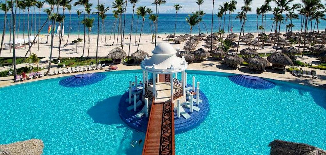 Luftaufnahme des Pools im Melia Caribe Beach Resort mit Sonnenschirmen und Palmen