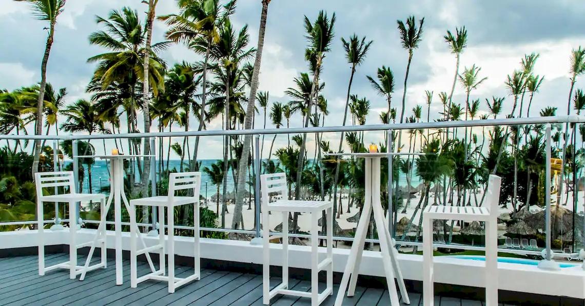 Terrasse des Melia Caribe Beach Resort mit Blick auf den Ozean und weiße Stühle