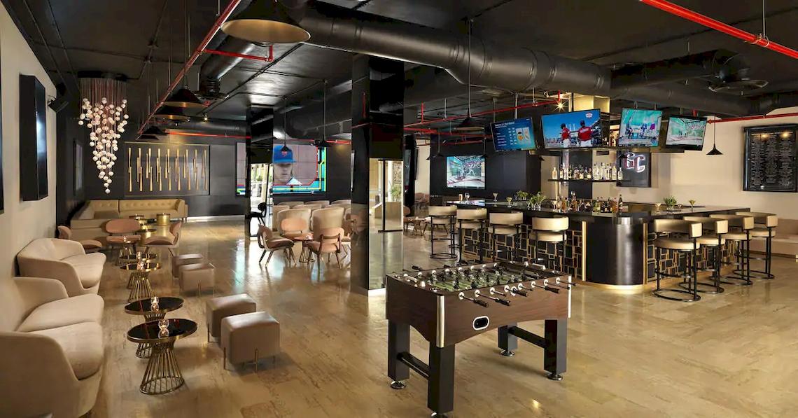 Loungebereich des Melia Caribe Beach Resorts mit Fernsehern, Bar, Fußballtisch und Möbeln.
