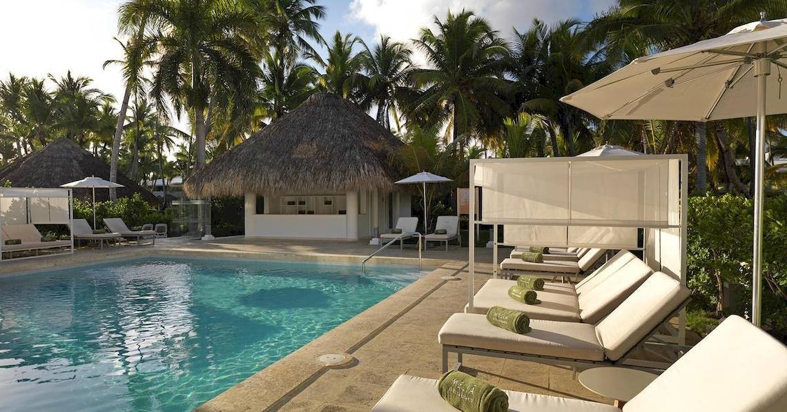 Pool-Lounge-Bereich im Melia Caribe Beach Resort mit Sonnenliegen und Sonnenschirmen.