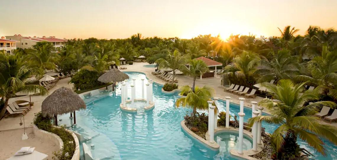 Außenbereich des Melia Caribe Strand Resorts mit Pool, Sonnenliegen und Palmen