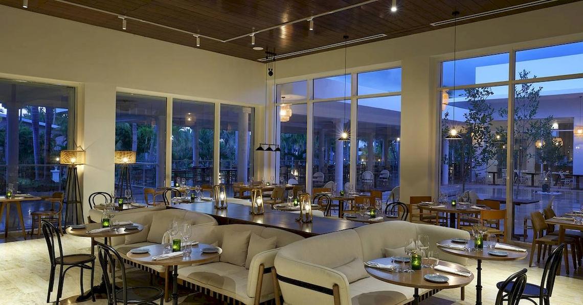 Innenbereich des Restaurants im Melia Caribe Beach Resort mit großen Fenstern und modernen Möbeln.