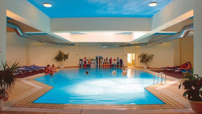 Innenpool des Pernera Beach Hotels mit mehreren Schwimmern und Lounge-Bereichen.