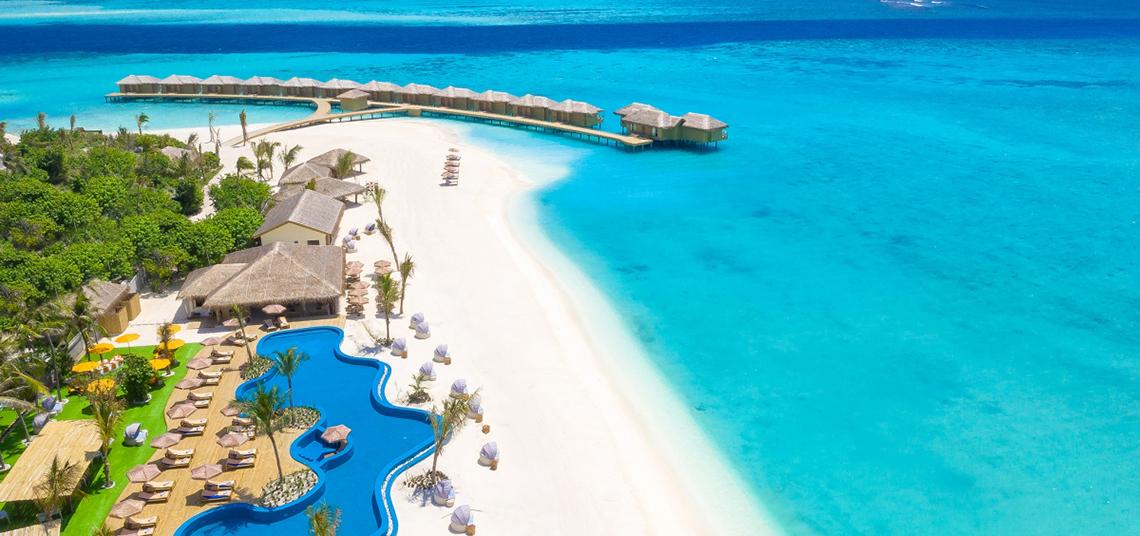 Luftaufnahme des You & Me Maldives Resorts mit Strand, Schwimmbad und Wasservillen.