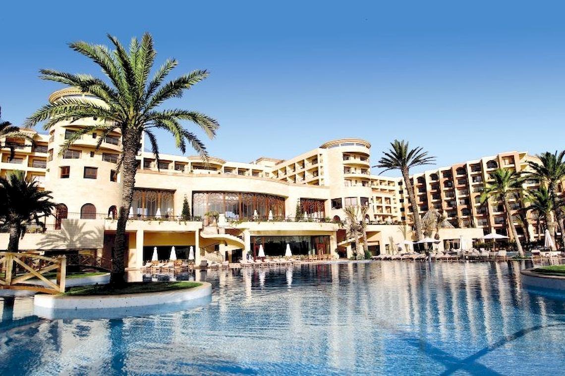 Außenansicht des Mövenpick Resort & Marine Spa Sousse mit großem Pool und Palmen