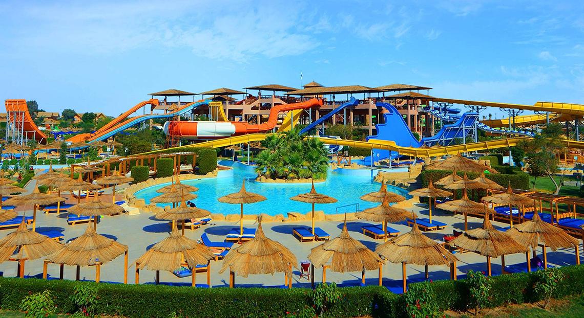 Außenansicht des Pickalbatros Jungle Aqua Park Resorts mit Wasserrutschen und Sonnenliegen.