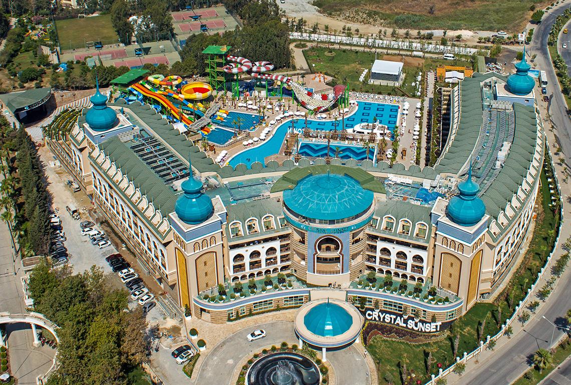 Außenansicht des Crystal Sunset Luxury Resort & Spa mit Wasserrutschen, Pools und blauen Kuppeldächern.