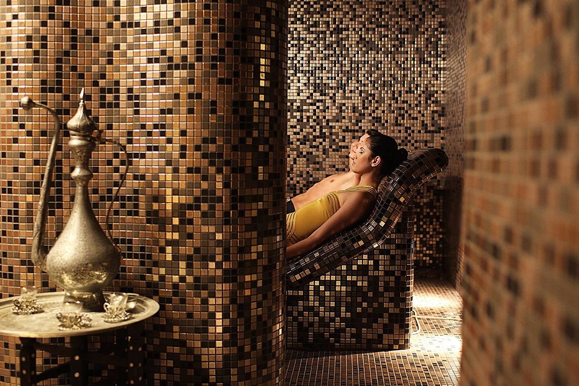 Ein Paar entspannt sich in der Sauna des Domes of Elounda, Autograph Collection Hotel.