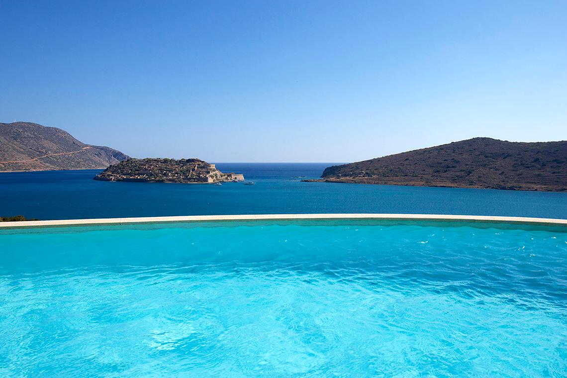 Außenpool des Domes of Elounda mit Blick auf das Meer und Inseln