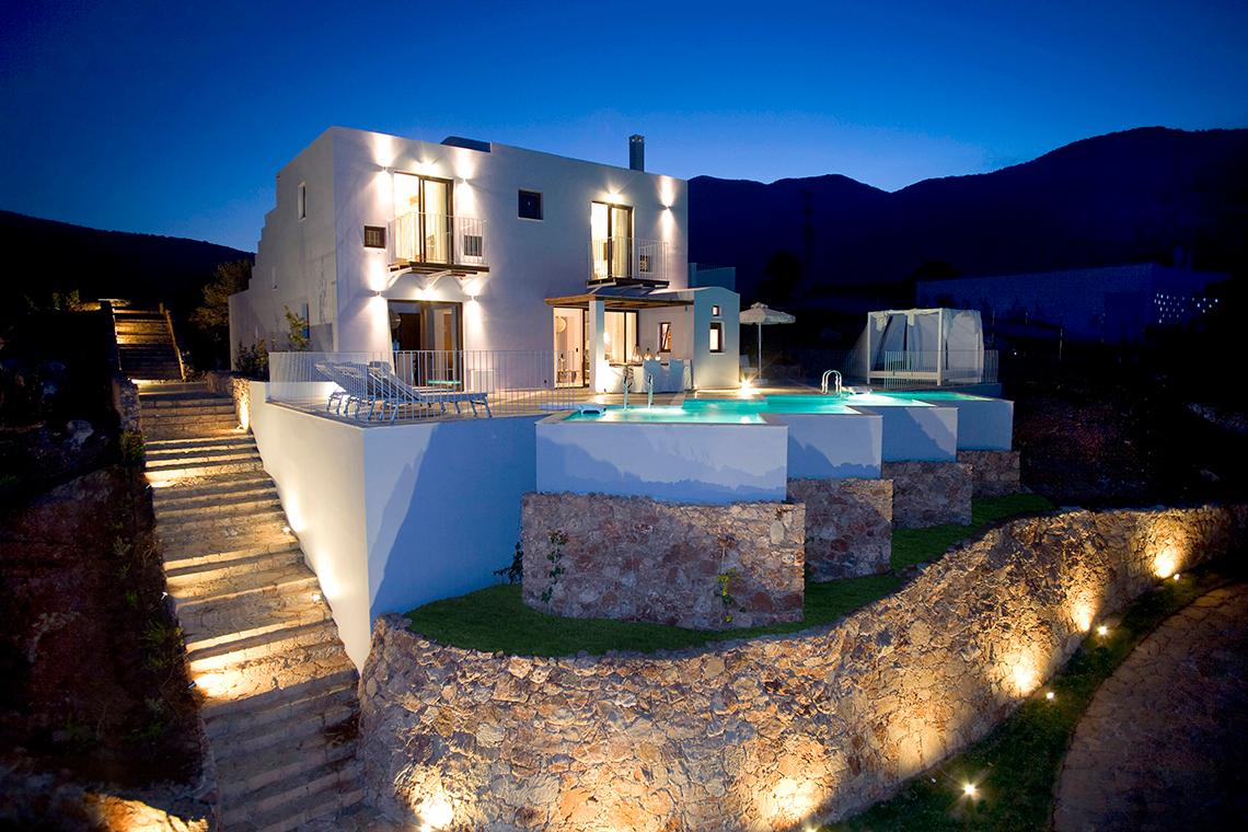 Außenansicht der Domes of Elounda, Autograph Collection Villa bei Nacht mit Pool und Terrasse