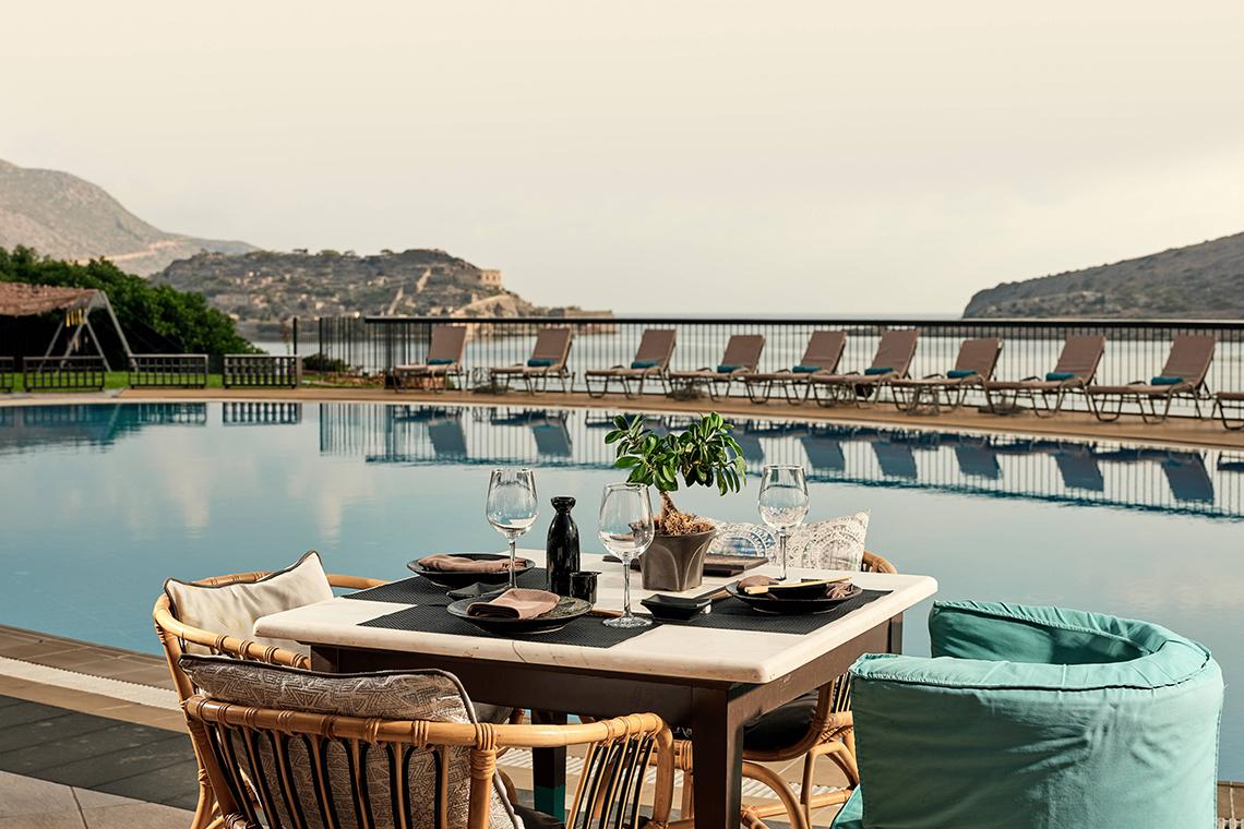 Terrasse des Domes of Elounda, Autograph Collection mit Blick auf den Pool und die Berge