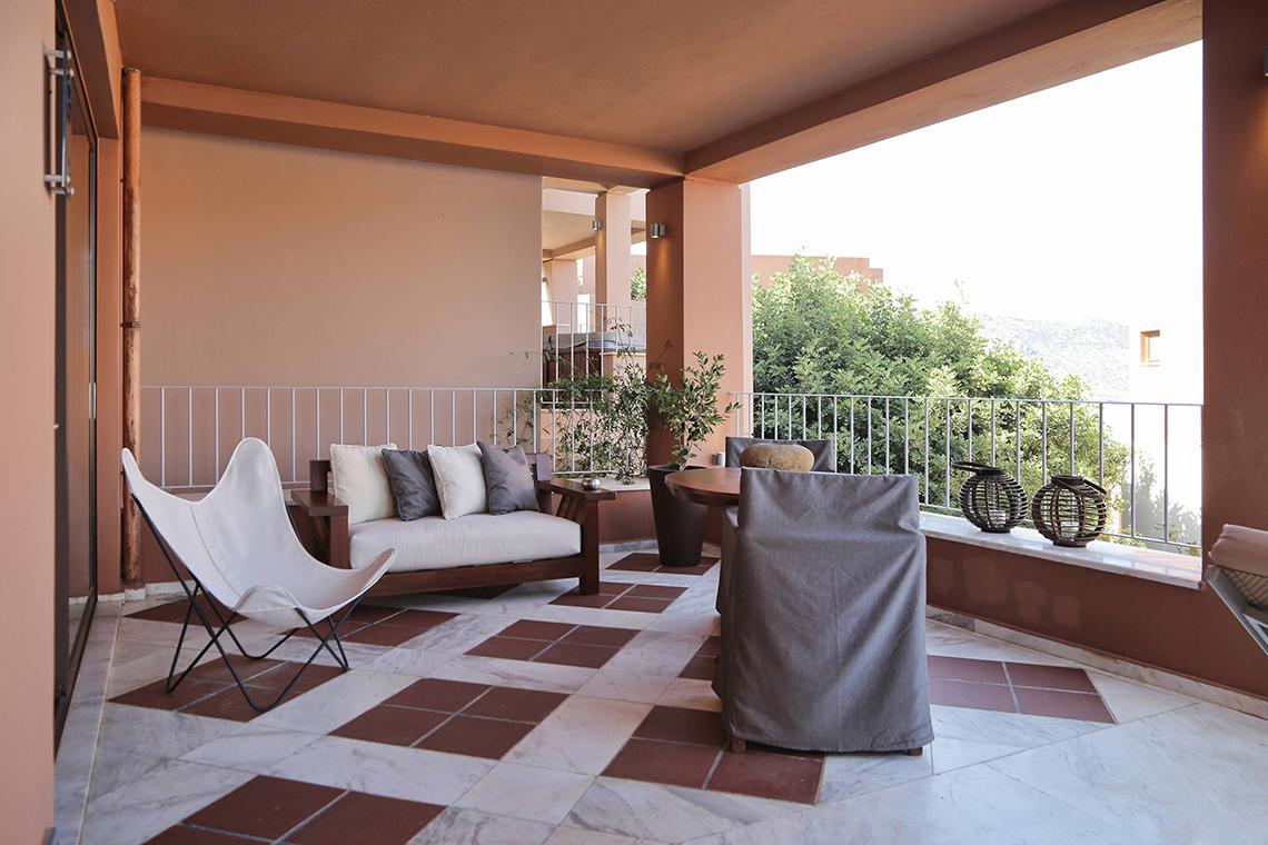Balkon im Domes of Elounda, Autograph Collection mit Möbeln und Pflanzen.