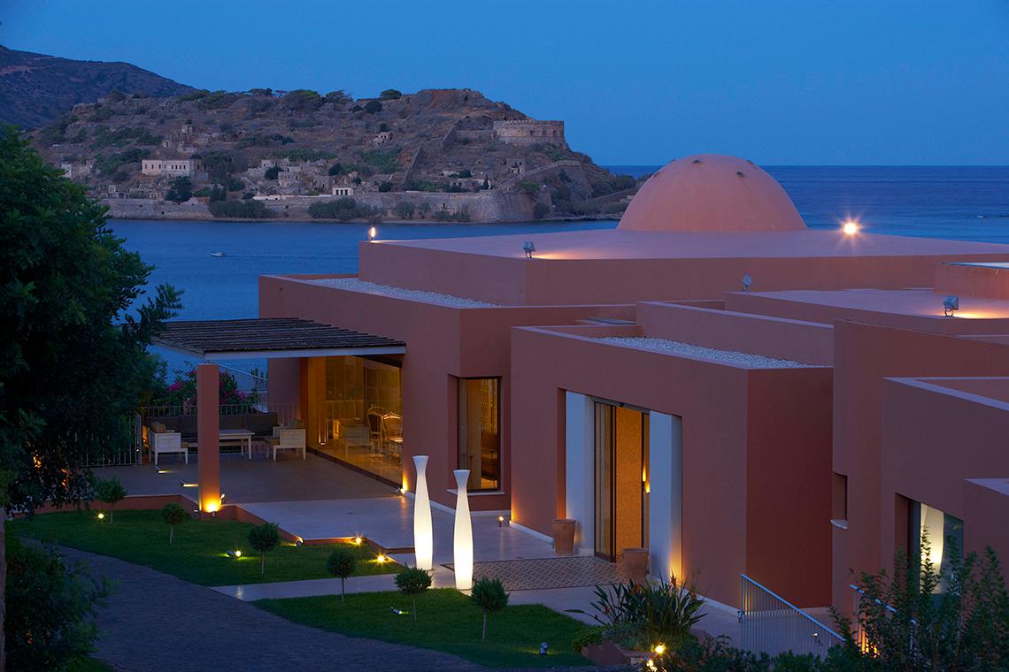 Abendansicht des Domes of Elounda, Autograph Collection mit Meer und Hügel im Hintergrund.
