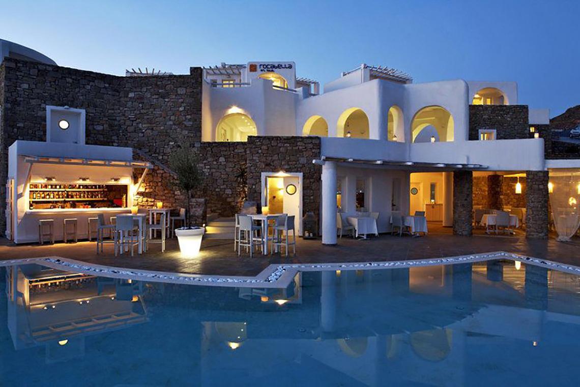 Außenbereich des Rocabella Mykonos Art Hotel & Spa mit Pool, Bar und Tischen